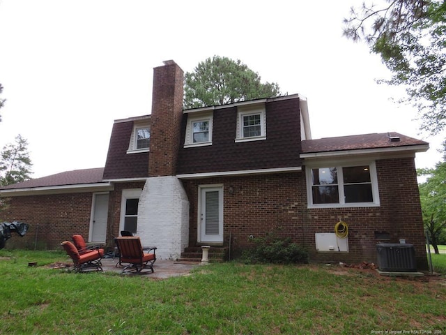 back of house featuring a lawn, cooling unit, and a patio area