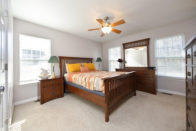 carpeted bedroom with ceiling fan and multiple windows