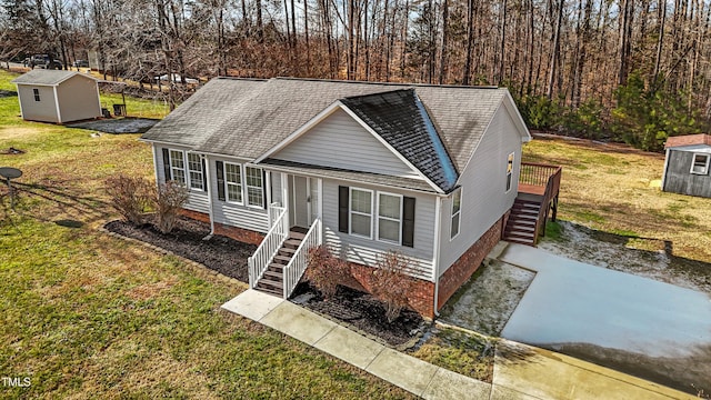 view of front of house with a front lawn and a storage shed