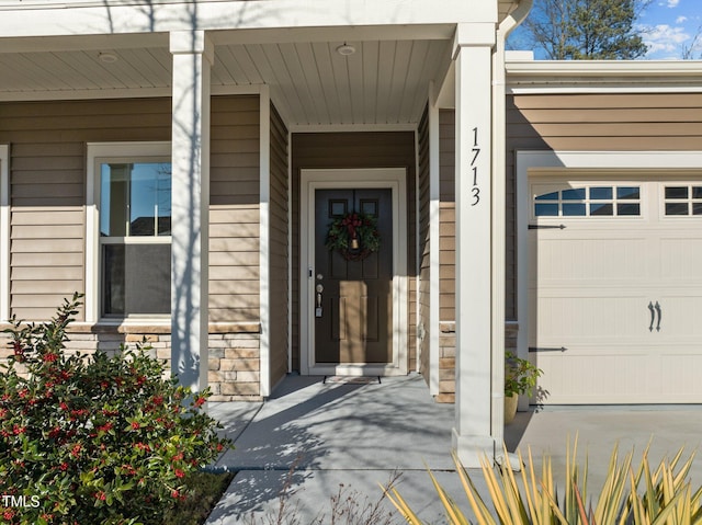 doorway to property with stone siding and an attached garage