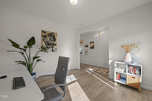 office area featuring light wood-style flooring, visible vents, and baseboards