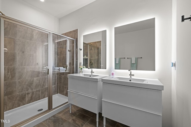 full bathroom featuring a sink, two vanities, and a shower stall