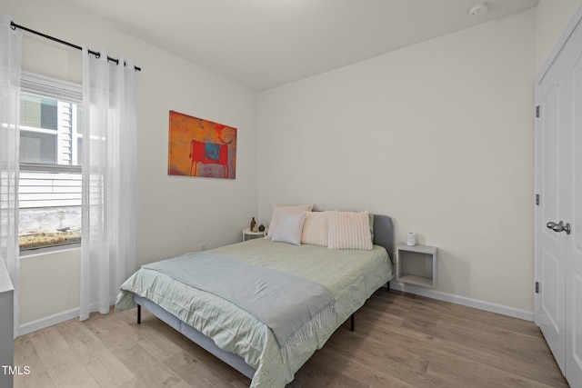 bedroom featuring baseboards and wood finished floors