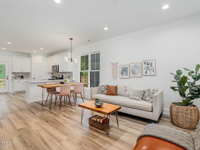 living room with light wood-type flooring and a notable chandelier