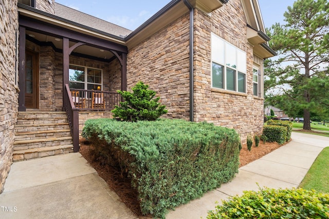 view of side of property featuring covered porch