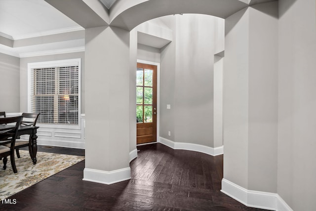 entryway with dark hardwood / wood-style flooring and crown molding