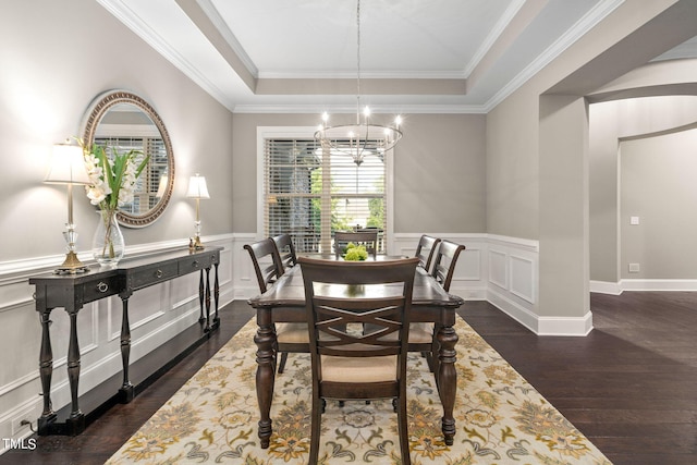 dining room featuring a tray ceiling, ornamental molding, dark hardwood / wood-style floors, and a notable chandelier