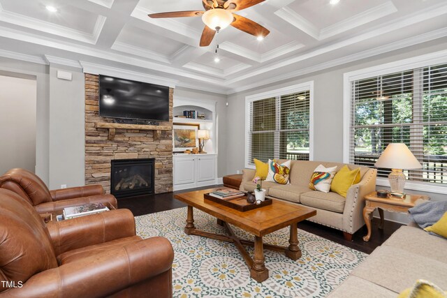 living room with a stone fireplace, crown molding, ceiling fan, and hardwood / wood-style flooring