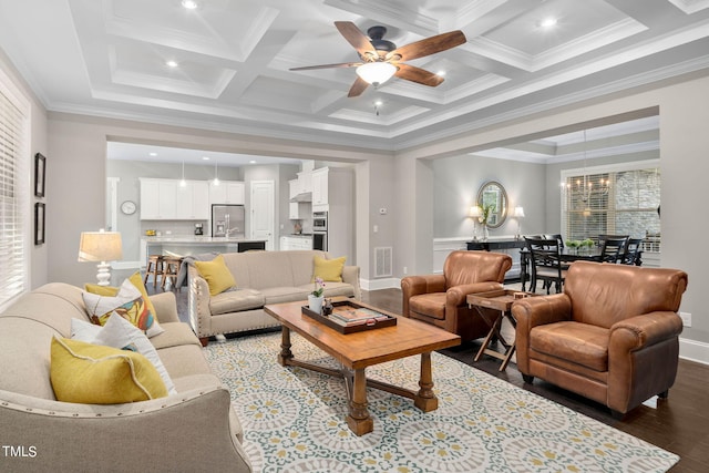 living room with coffered ceiling, ceiling fan with notable chandelier, hardwood / wood-style flooring, ornamental molding, and beam ceiling