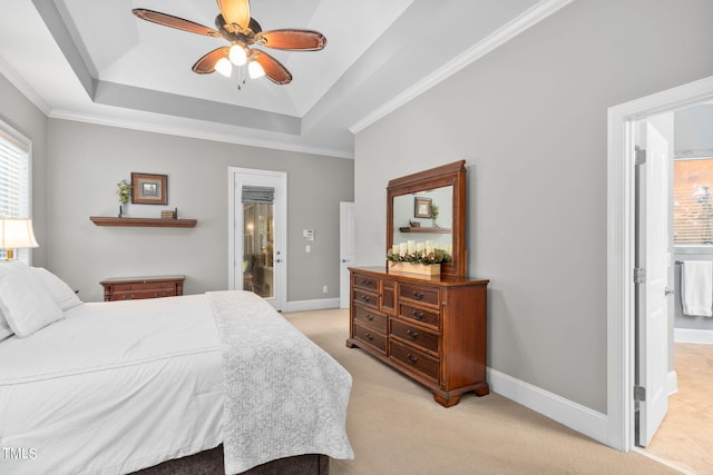 carpeted bedroom featuring ceiling fan, ensuite bath, ornamental molding, and a tray ceiling