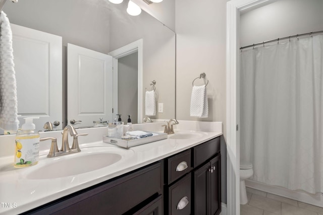 bathroom with tile patterned flooring, vanity, and toilet