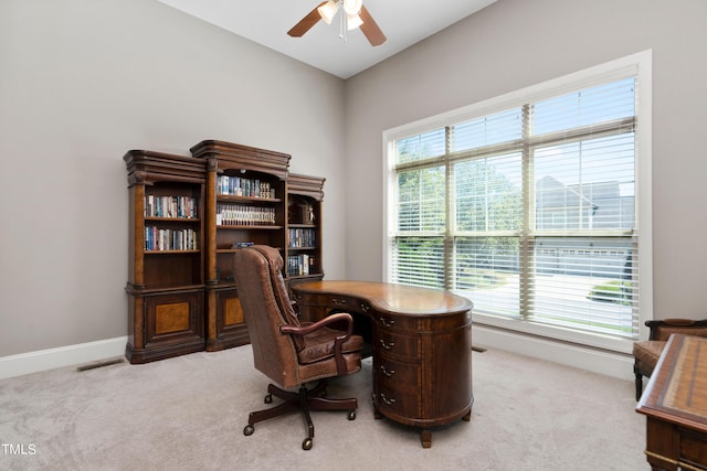 office space with plenty of natural light, ceiling fan, and light carpet