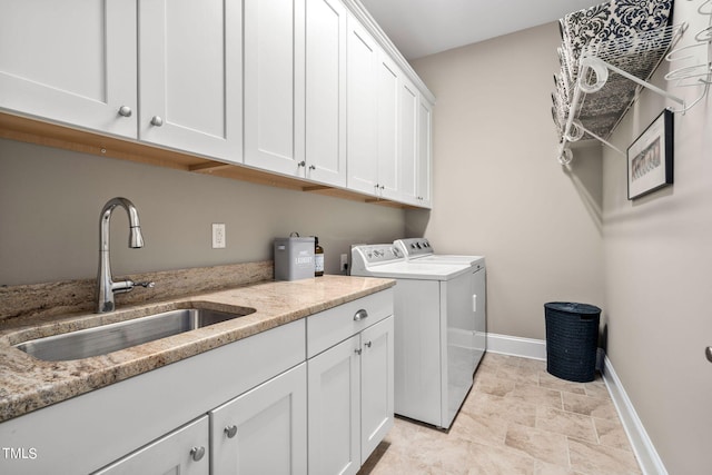 laundry area featuring cabinets, washing machine and dryer, and sink