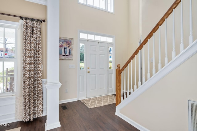 foyer with visible vents, dark wood-type flooring, and a wealth of natural light