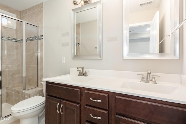 bathroom featuring toilet, an enclosed shower, and vanity