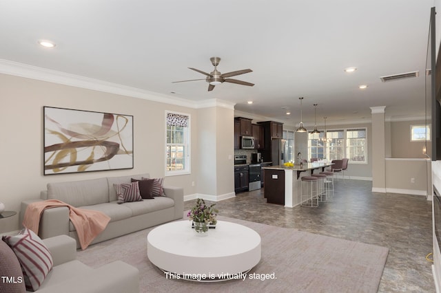 living room with sink, ceiling fan, and crown molding