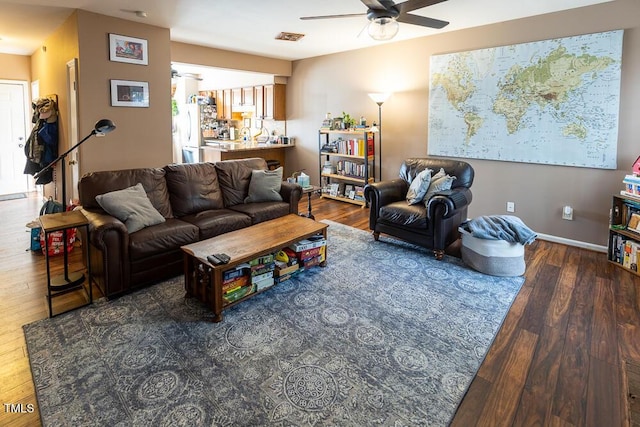 living room featuring ceiling fan and dark hardwood / wood-style floors