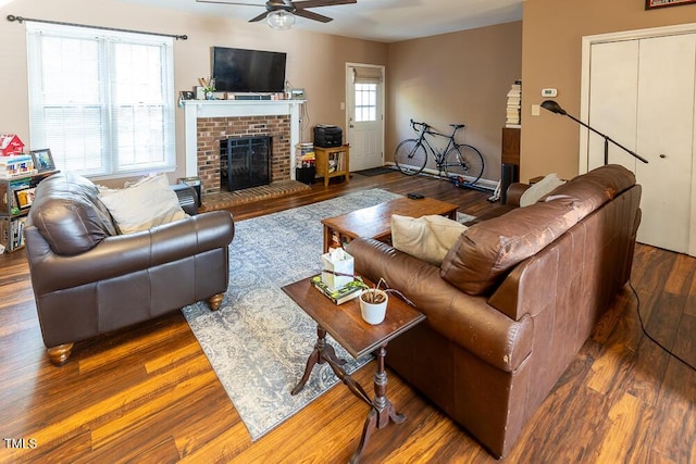 living room with ceiling fan, a wealth of natural light, a fireplace, and dark hardwood / wood-style floors