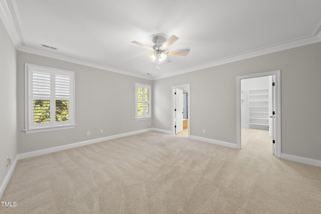 carpeted empty room with ceiling fan and ornamental molding