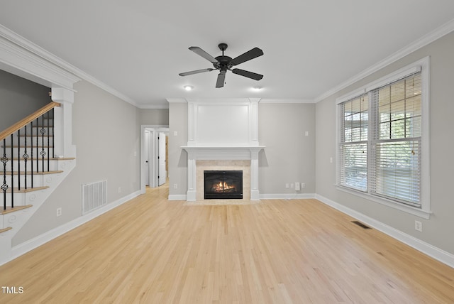 unfurnished living room featuring ceiling fan, a fireplace, light hardwood / wood-style flooring, and ornamental molding