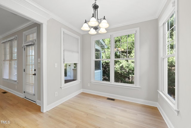 unfurnished dining area with light hardwood / wood-style flooring, crown molding, and a notable chandelier