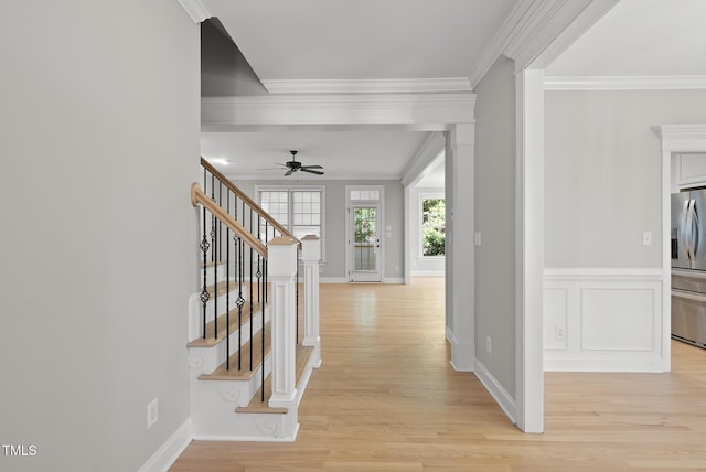 corridor with light hardwood / wood-style floors and ornamental molding