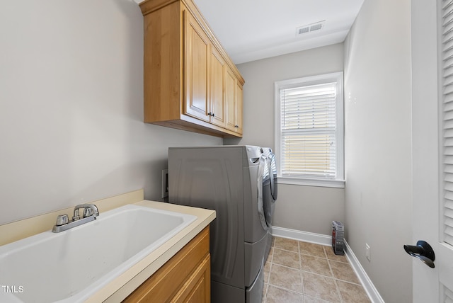 washroom with washer and dryer, light tile patterned flooring, cabinets, and sink