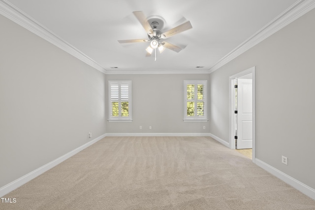 spare room with ceiling fan, crown molding, and light carpet