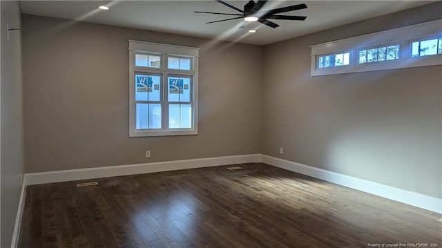 spare room featuring ceiling fan, dark hardwood / wood-style flooring, and a healthy amount of sunlight