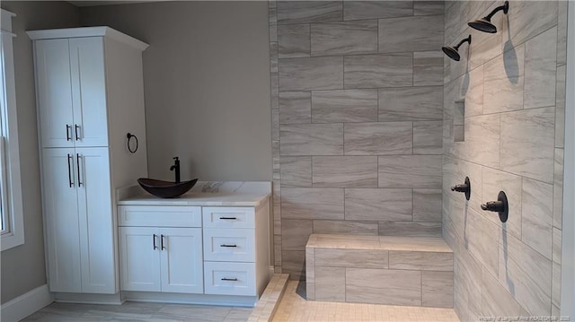 bathroom with vanity and a tile shower