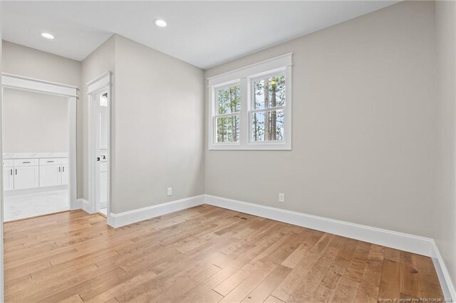 empty room featuring baseboards, recessed lighting, and light wood-style floors