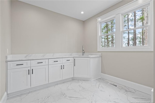 laundry room featuring recessed lighting, a sink, visible vents, baseboards, and marble finish floor