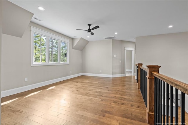 additional living space with baseboards, visible vents, and wood finished floors