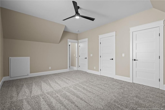 unfurnished bedroom with ceiling fan, carpet, baseboards, and vaulted ceiling