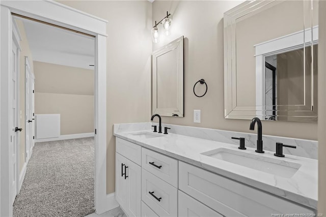 bathroom with double vanity, baseboards, and a sink