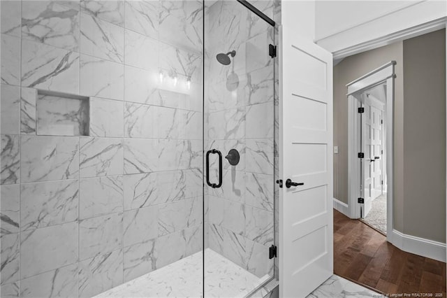 bathroom featuring a stall shower and baseboards