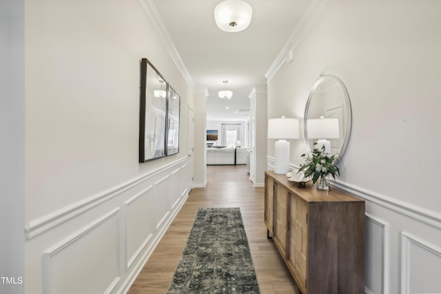 hallway with hardwood / wood-style floors and crown molding