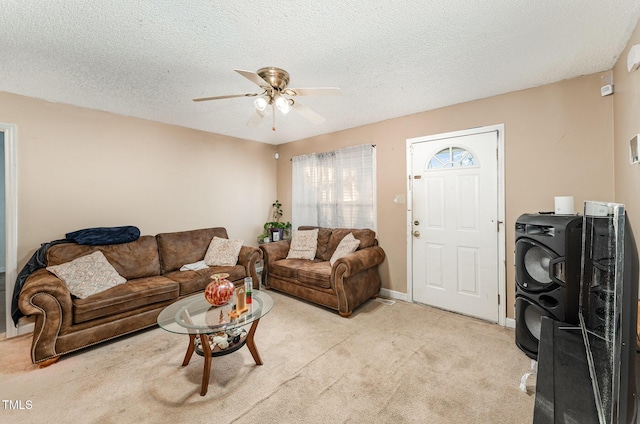 carpeted living room with ceiling fan and a textured ceiling