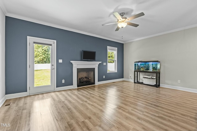 unfurnished living room with a wealth of natural light, crown molding, and ceiling fan