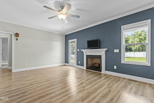 unfurnished living room featuring light wood-type flooring, crown molding, ceiling fan, and a healthy amount of sunlight