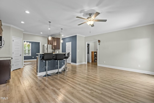 living room featuring ceiling fan, light hardwood / wood-style floors, and crown molding