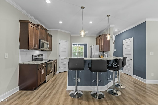 kitchen featuring a breakfast bar, light stone countertops, stainless steel appliances, decorative light fixtures, and dark brown cabinets