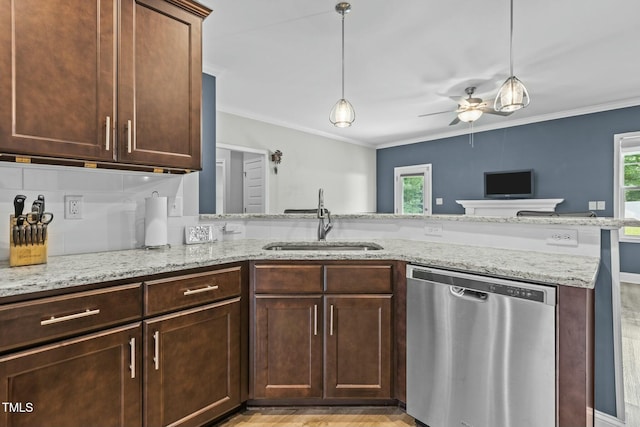 kitchen featuring sink, hanging light fixtures, light stone counters, stainless steel dishwasher, and kitchen peninsula