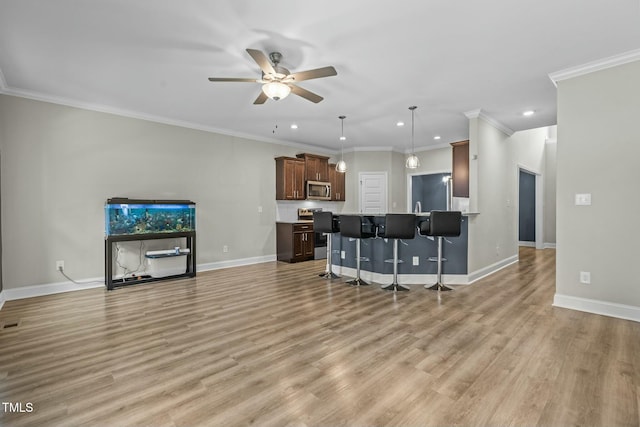 living room with ceiling fan, light wood-type flooring, and ornamental molding