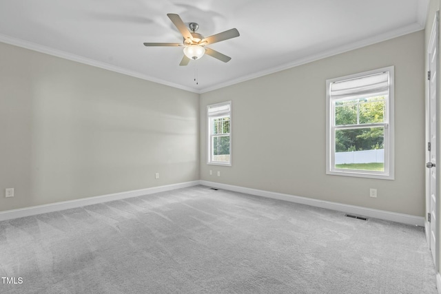 empty room featuring crown molding, ceiling fan, and light colored carpet