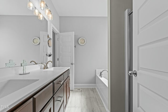 bathroom with vanity and tiled bath