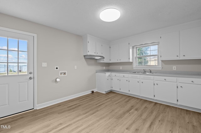 kitchen featuring a textured ceiling, white cabinetry, and sink