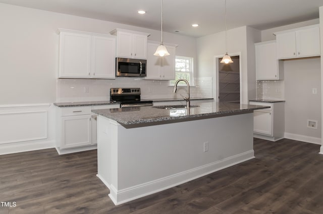 kitchen with white cabinetry, sink, stainless steel appliances, and a center island with sink