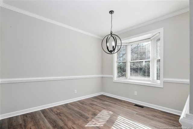 unfurnished dining area featuring hardwood / wood-style floors, crown molding, and a notable chandelier