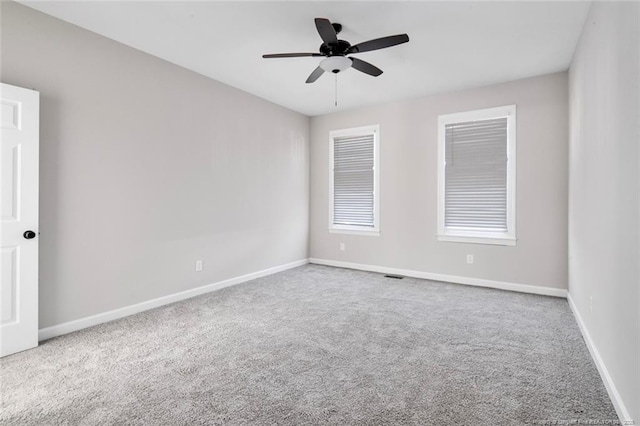 carpeted spare room featuring ceiling fan